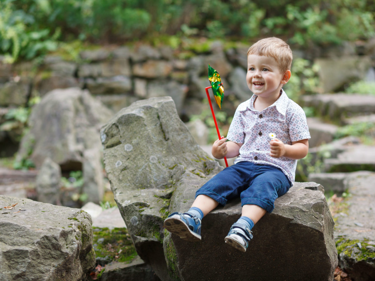 child enjoying boulder in yard