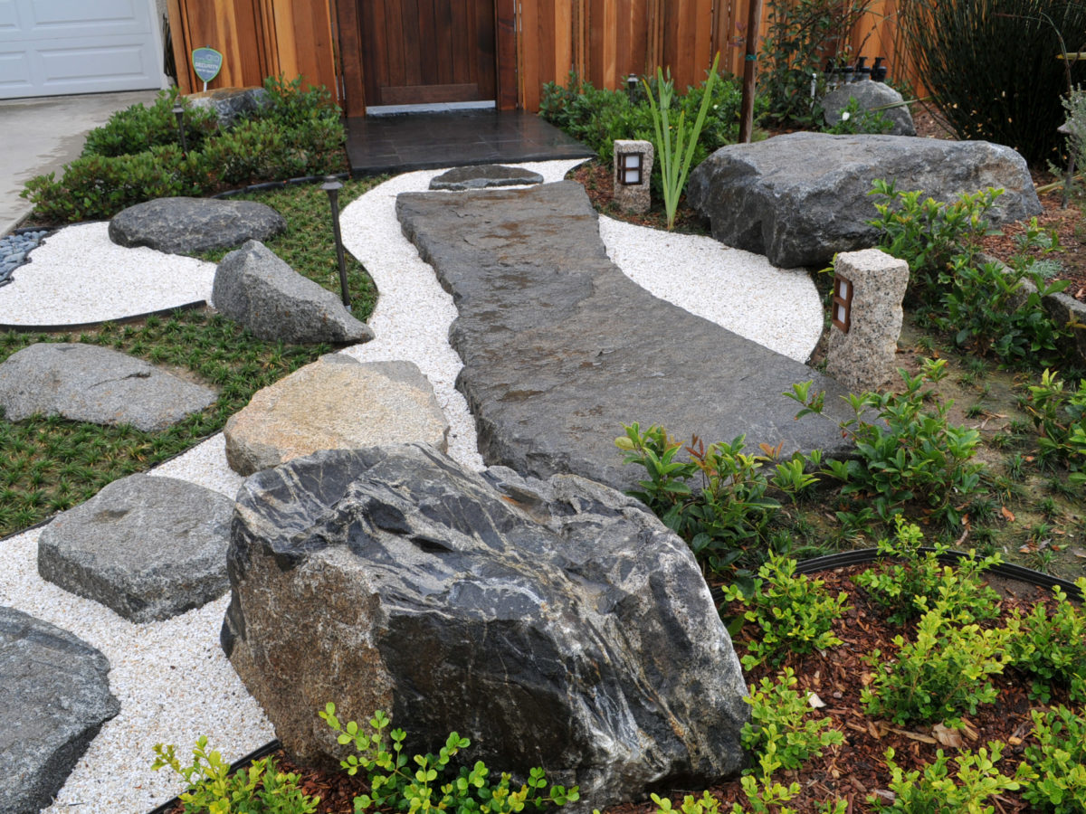 Rock slab pathway with white sand in zen garden